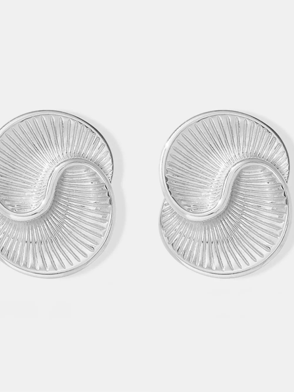 Sculptural silver vermeil shell stud earrings with radiating lines.