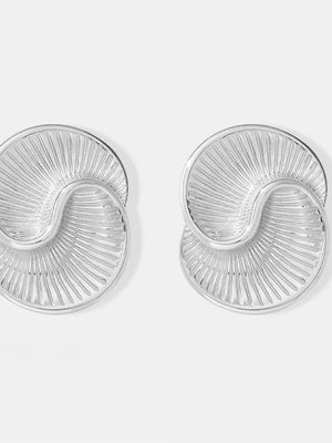 Sculptural silver vermeil shell stud earrings with radiating lines.