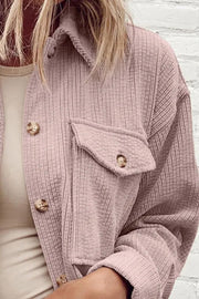 Textured corduroy utility jacket in dusty pink with button closure and chest pocket.