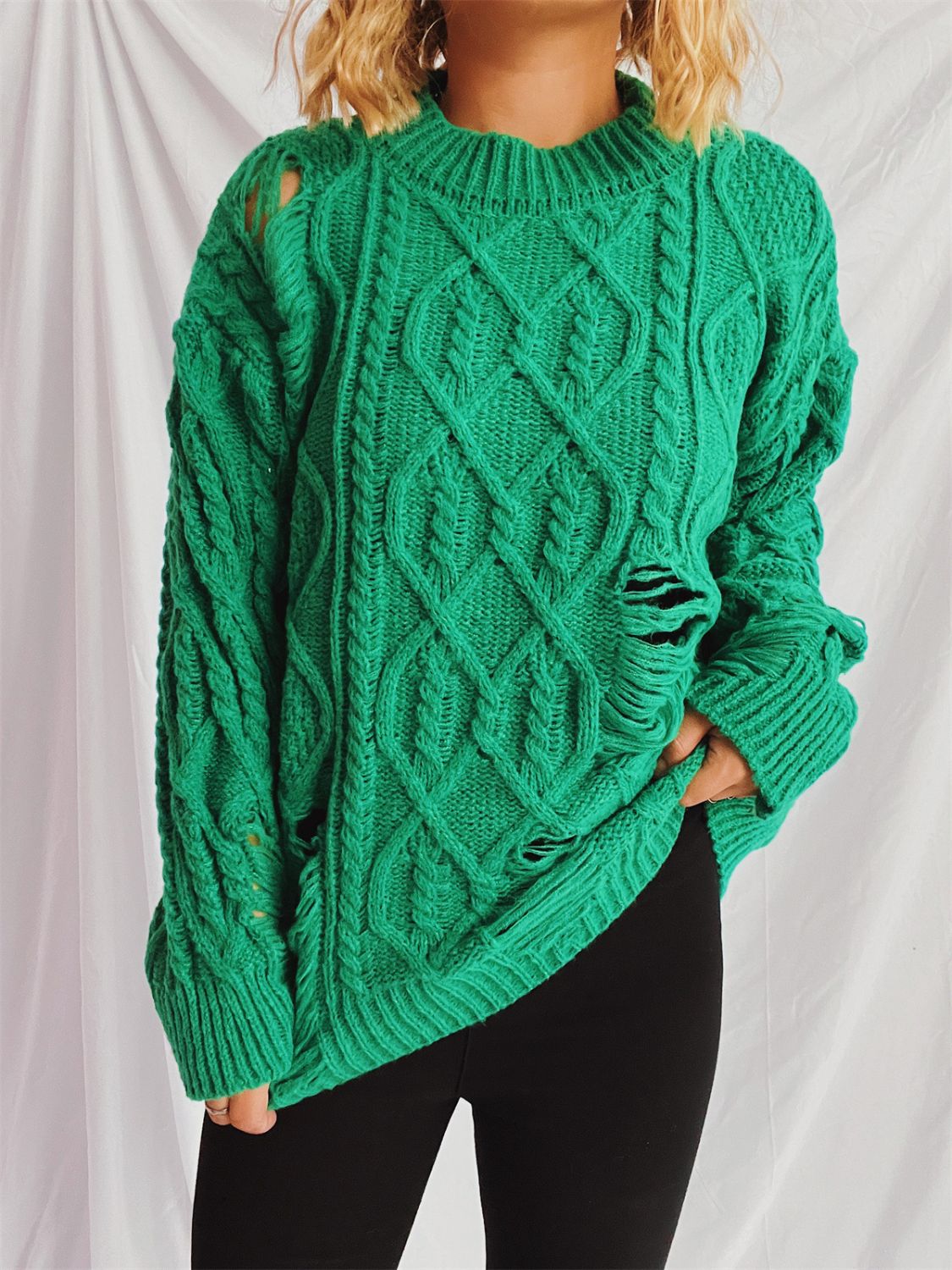 Green distressed cable knit sweater with ripped details and crew neck.