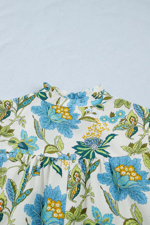 Floral mini dress with ruffled neckline and blue, green, yellow floral print on white cotton.