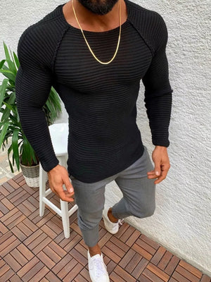 Black ribbed knit long sleeve sweater with crew neck and raglan sleeves.