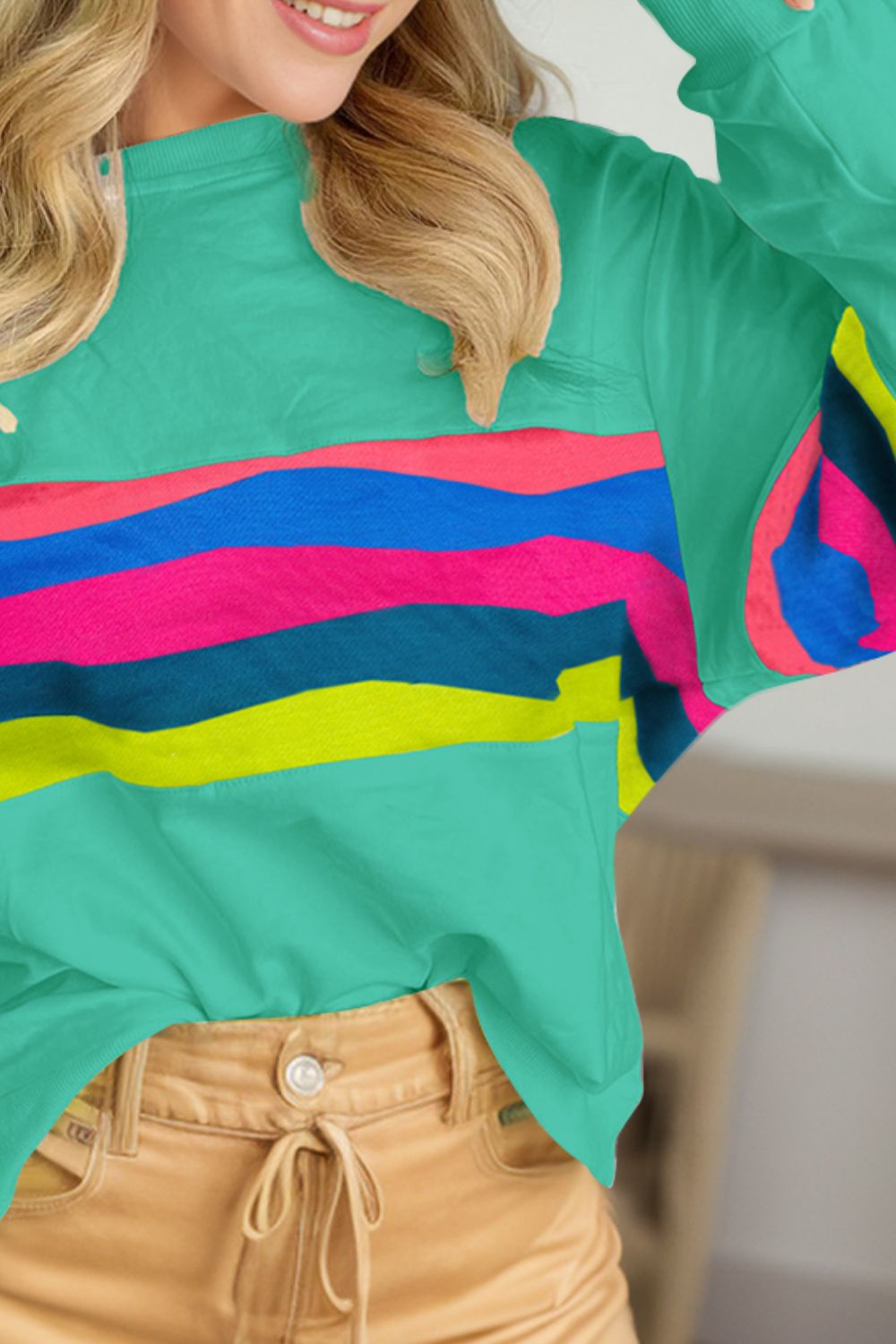 Turquoise crewneck sweatshirt with horizontal colorblock stripes in pink, blue, and yellow.