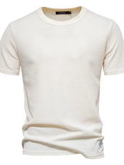 Ivory textured crew-neck t-shirt knit with short sleeves and a waffle knit pattern.
