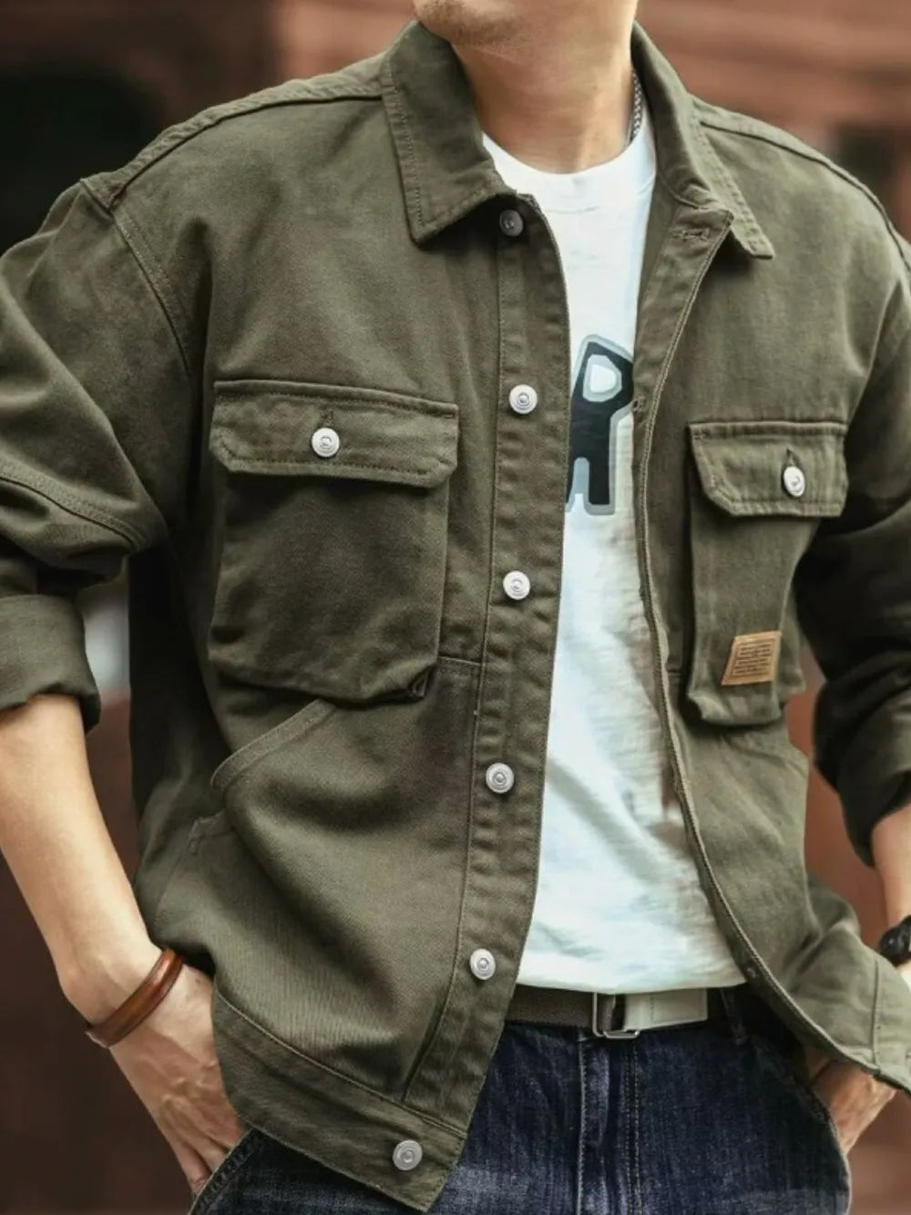 Moss green washed cotton chore jacket with four utility pockets and button closure.