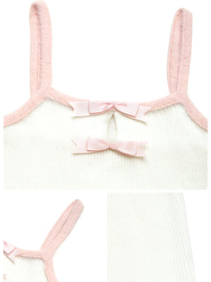 White ribbed camisole with pink trim and two pink bow accents at the neckline.
