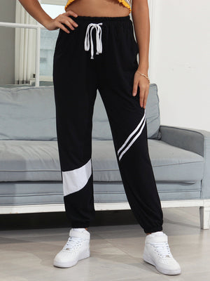 Black joggers with white diagonal panel details and drawstring waist.