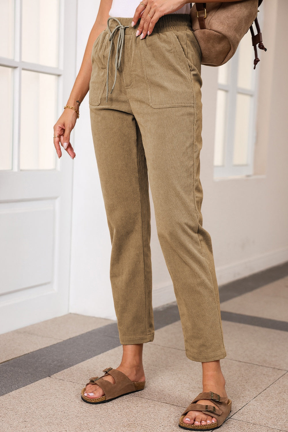 Khaki corduroy drawstring trousers with slant pockets and a relaxed fit.