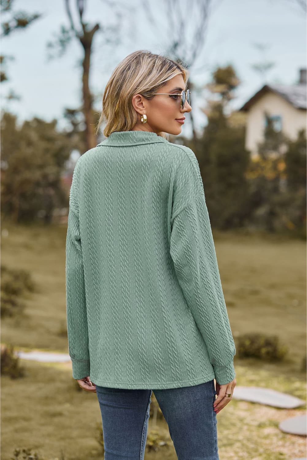 Sage green textured cable knit polo top with a collared neckline and long sleeves.