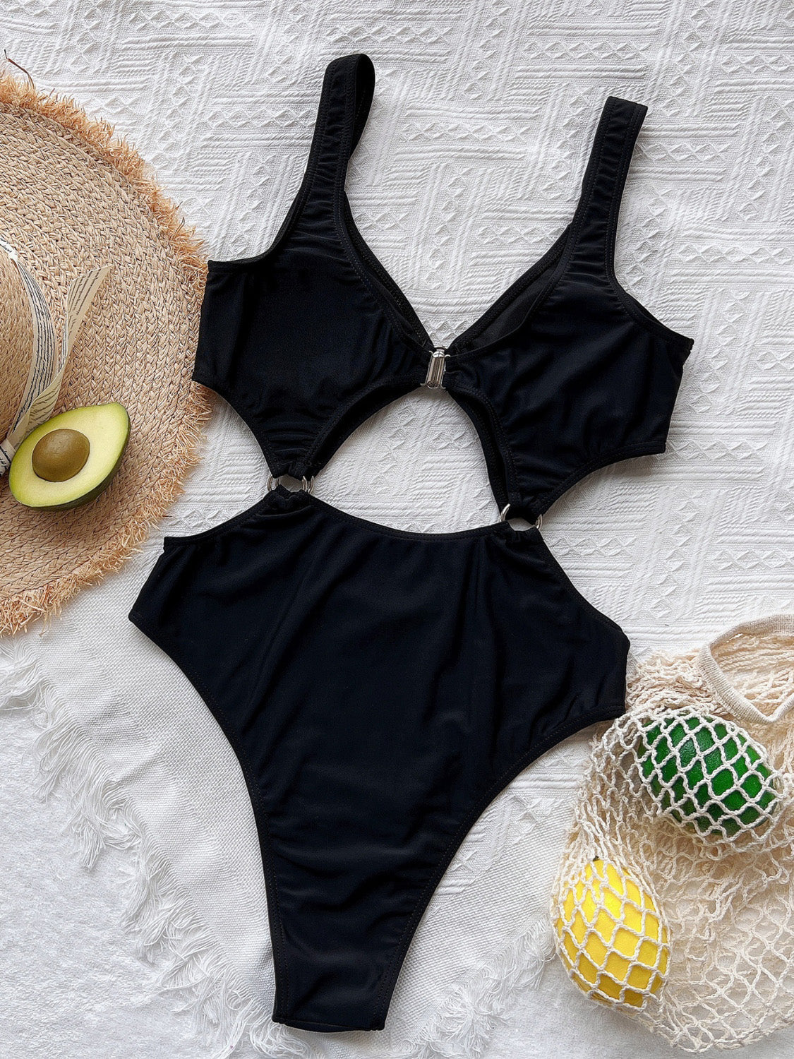 Black one-piece swimsuit with ring details and cutouts at the waist and bust.