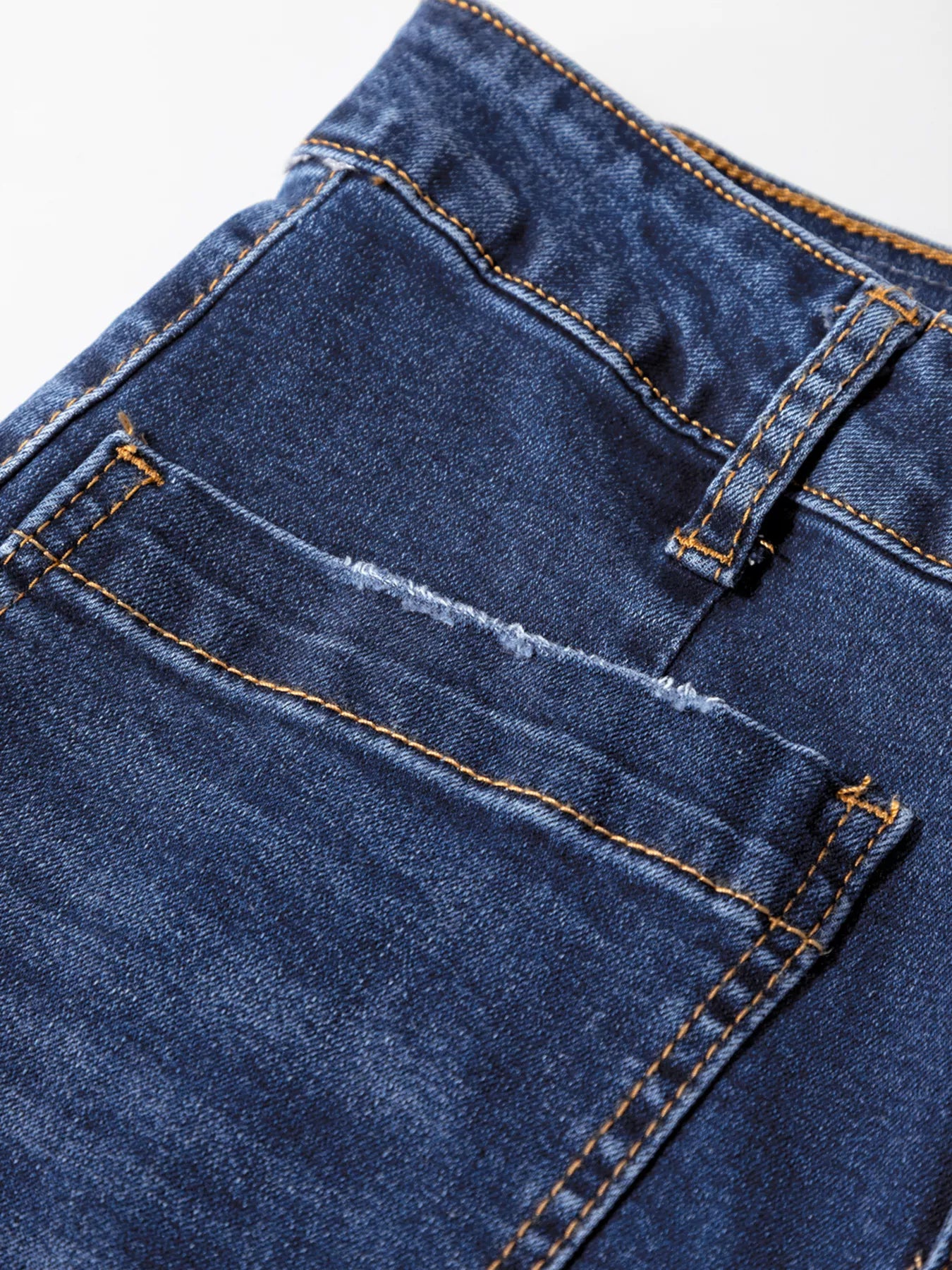 Medium wash denim jeans with patch pockets and frayed detail.