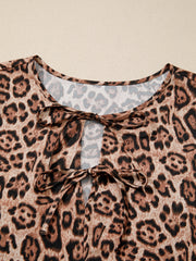 Leopard print blouse with tie neck detail and puff sleeves.