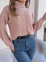 Dusty pink acrylic cable knit turtleneck sweater with drop shoulder and textured pattern.