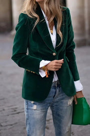 Emerald velvet blazer with gold buttons and lapel collar, styled with a white shirt and jeans.