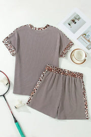 Brown ribbed knit two-piece set with leopard trim on neckline, sleeves, and shorts.
