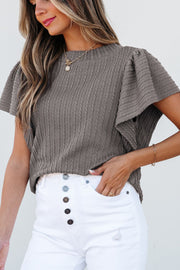 Gray cable knit flutter sleeve top with textured pattern.