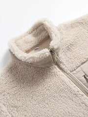 Beige sherpa zip-up jacket with a stand collar and contrasting fabric details.