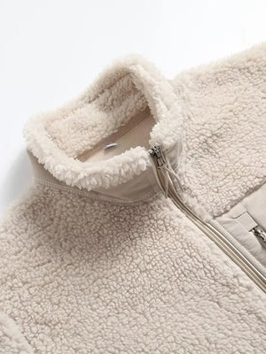 Beige sherpa zip-up jacket with a stand collar and contrasting fabric details.