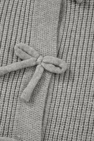 Gray ribbed knit cardigan with a tie-front detail and bow accent.