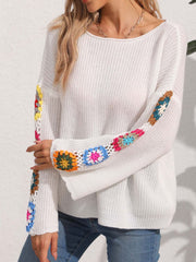 White knit sweater with colorful granny square crochet sleeves and a boat neckline.