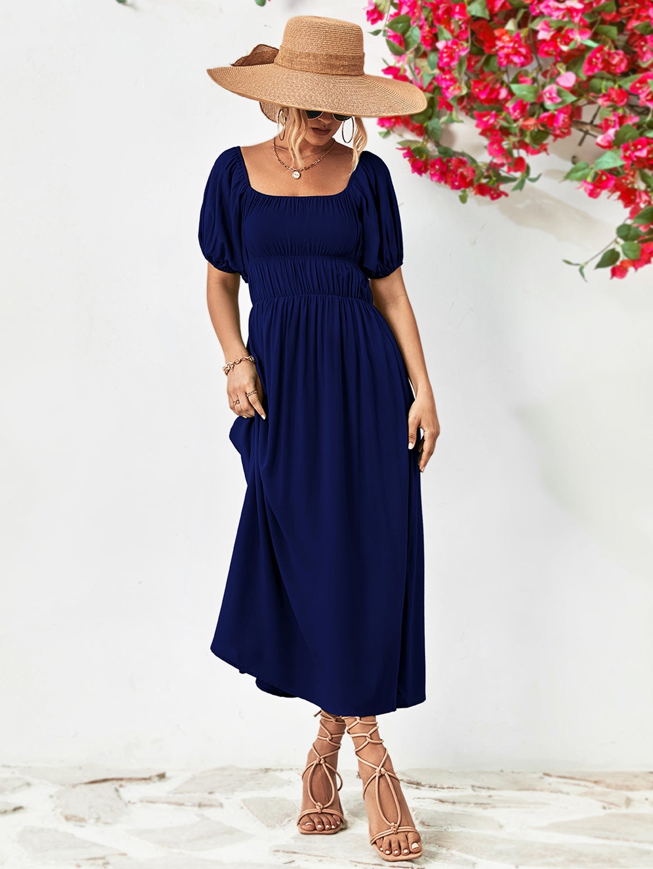 Dark blue midi dress with gathered bodice, square neckline, and puff sleeves.