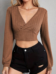Textured wrap-front crop top in tan with long sleeves and a V-neck.