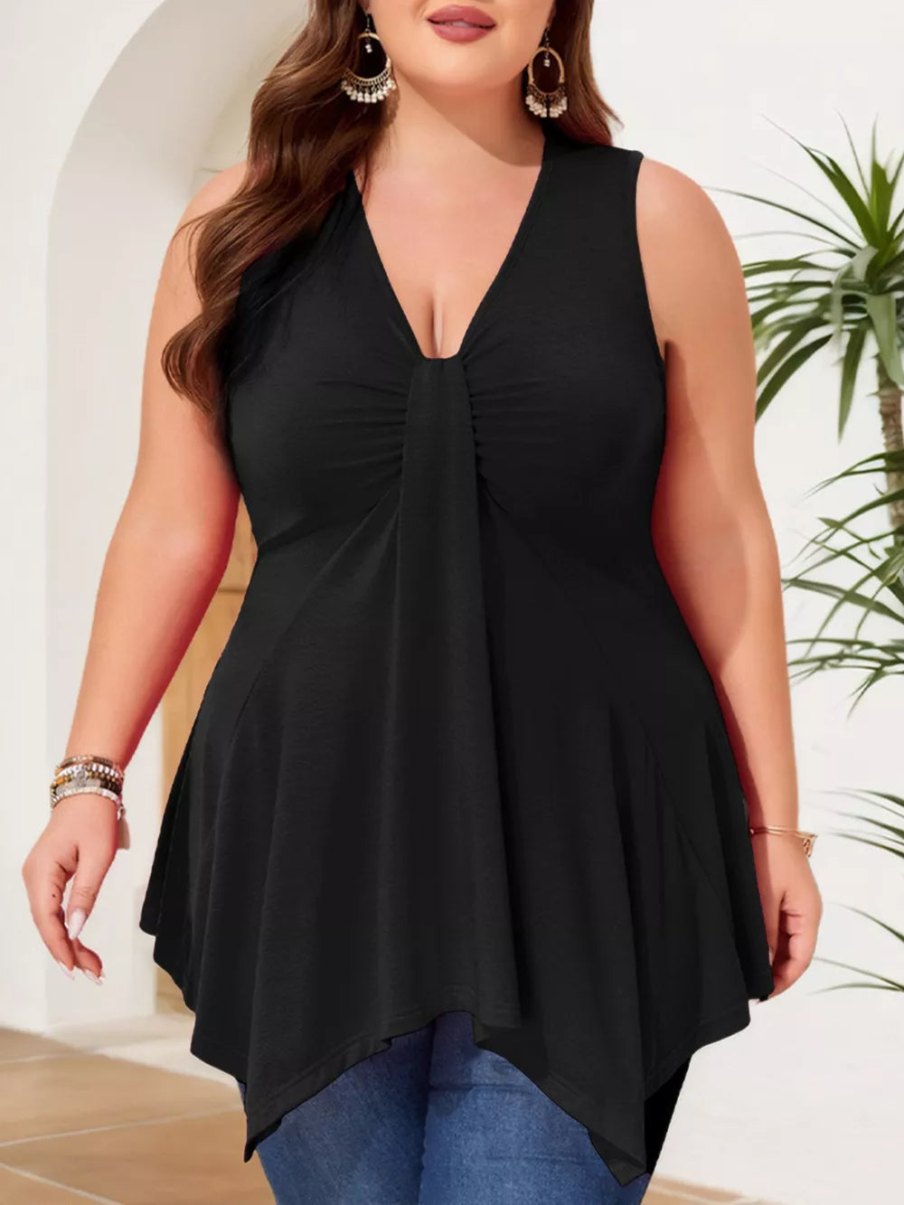 Plus-size black asymmetrical tank top with ruched V-neckline and flowy hem.