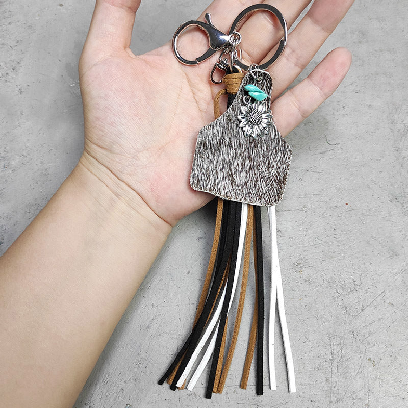 Leopard print tag keychain with silver sunflower charm, turquoise accent, and multi-color tassels.