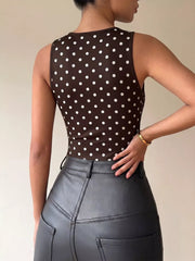 Brown polka dot sleeveless bodysuit with a cowl neck detail.