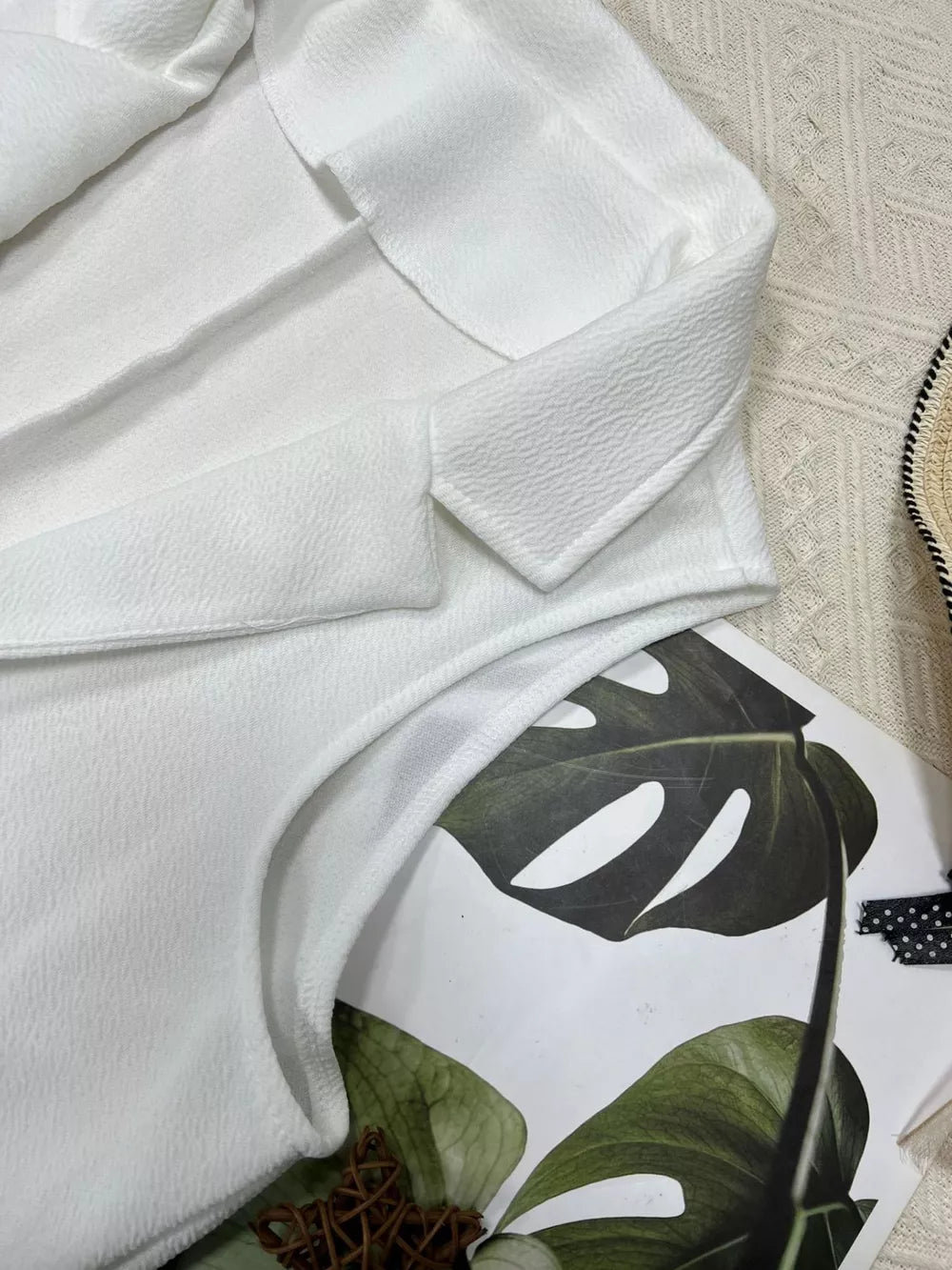 White longline vest coat with textured fabric and notch collar.