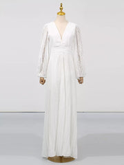 White maxi dress with V-neck, balloon sleeves, and pleated skirt.