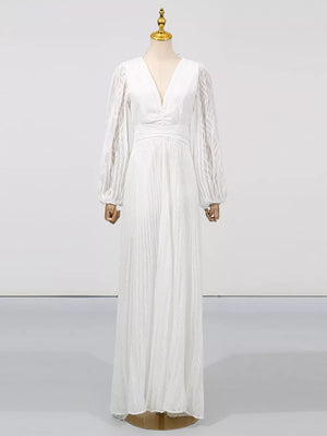 White maxi dress with V-neck, balloon sleeves, and pleated skirt.