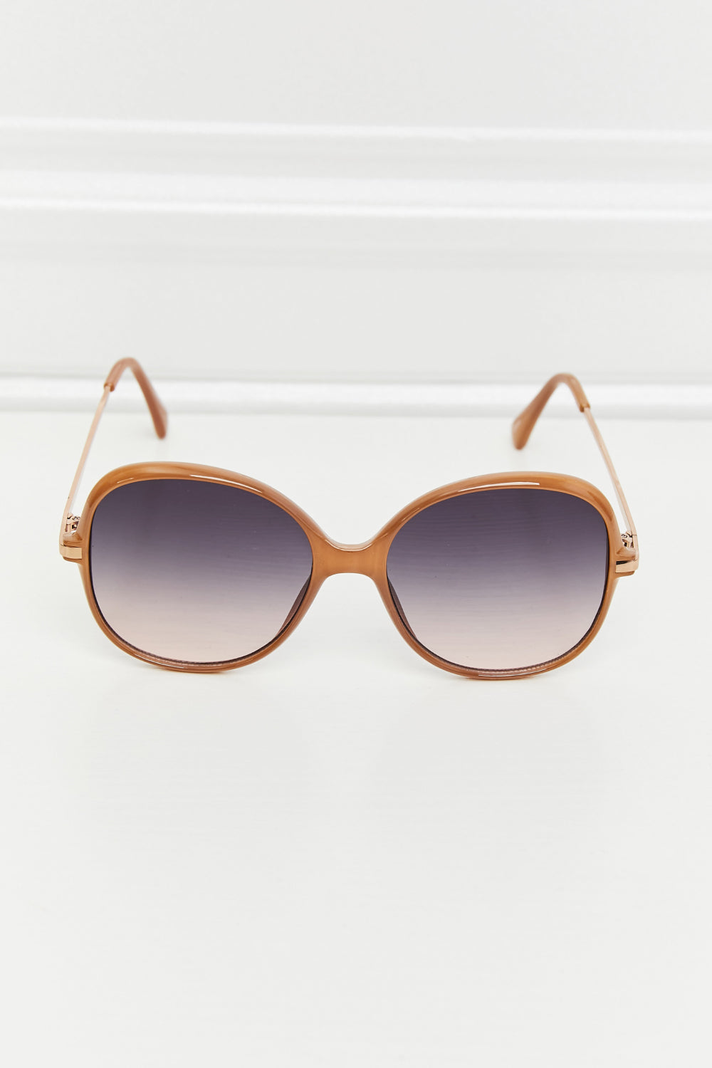 Oversized round frame sunglasses in caramel with gradient lenses and thin metal arms.