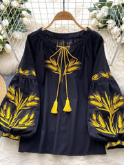 Black embroidered tie-neck blouse with yellow wheat detail and tassel ties.