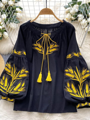 Black embroidered tie-neck blouse with yellow wheat detail and tassel ties.
