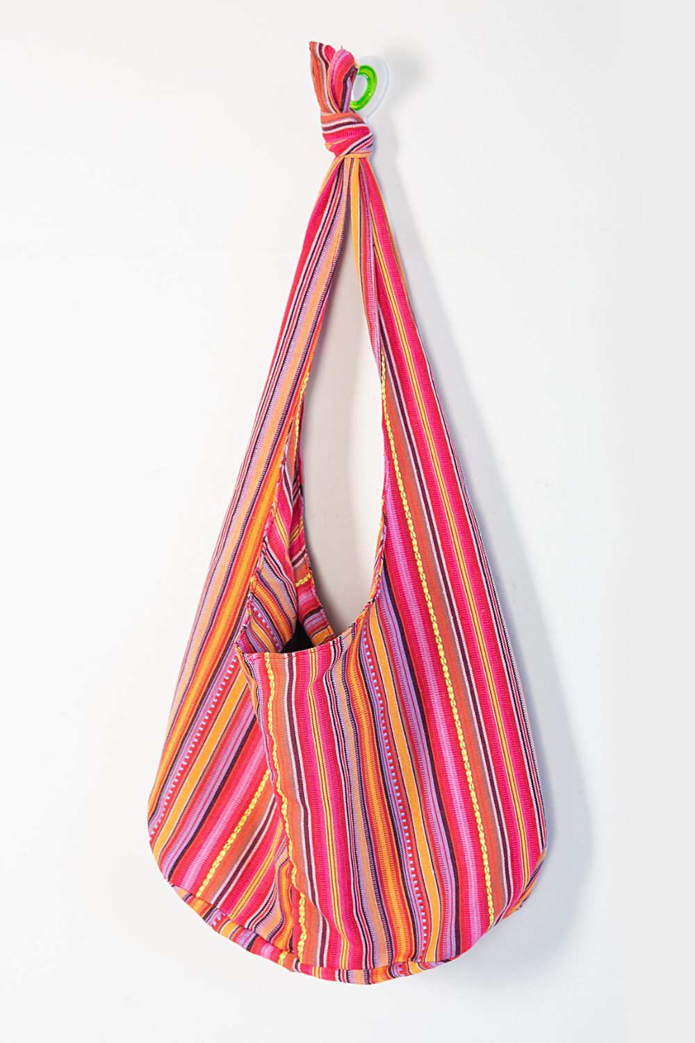 Tribal weave shoulder bag in multicolor stripes with a front pocket and knotted strap.