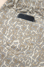 Denim shorts with leopard print and a back pocket holding a smartphone.