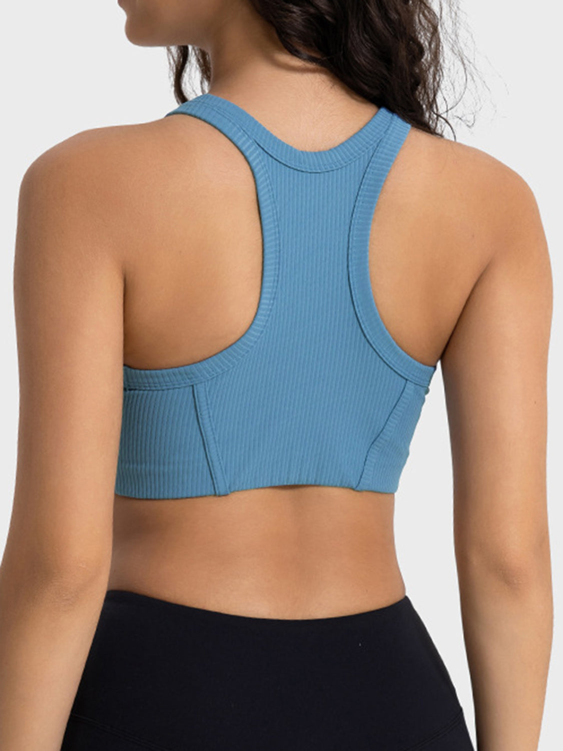 Blue ribbed racerback crop top with contour stitching and racerback detail.
