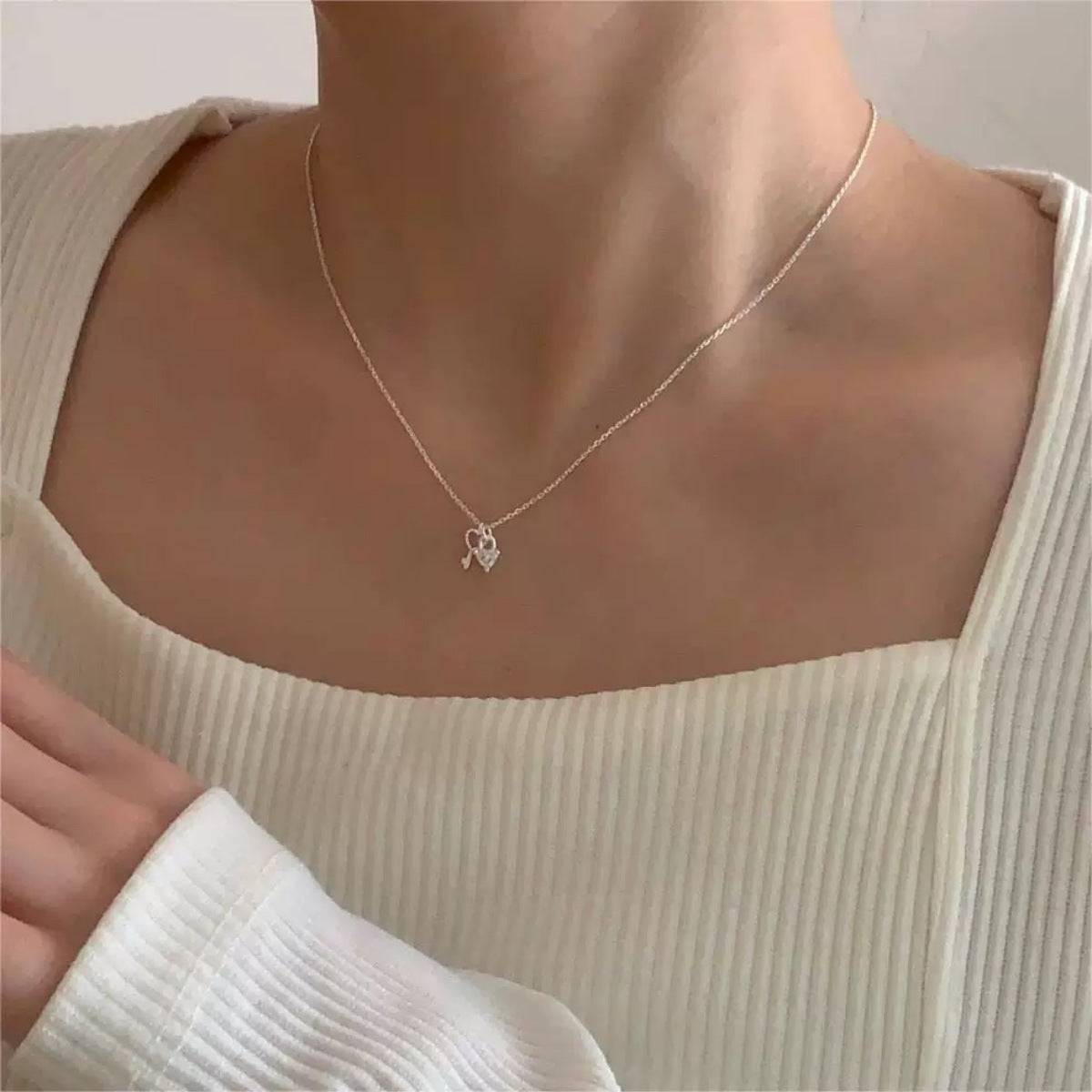 Sterling silver dainty necklace with a heart lock and key charm.