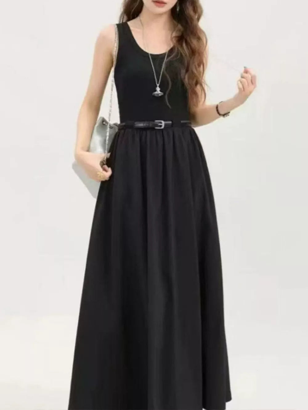 Black midi dress with a fitted tank top and flowing skirt, cinched with a belt.