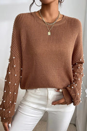 Brown cable knit sweater with pearl embellished sleeves and crew neck.