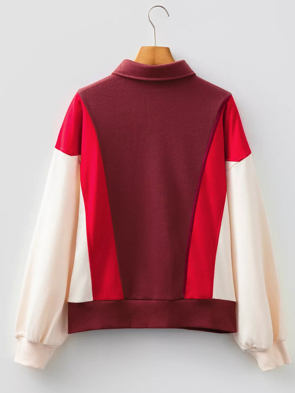 Oversized color block sweatshirt with a collared neckline and long sleeves in red, burgundy, and cream cotton.
