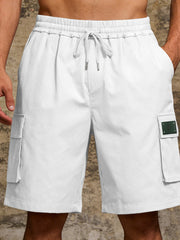White cargo shorts with drawstring waist and side pocket detail.