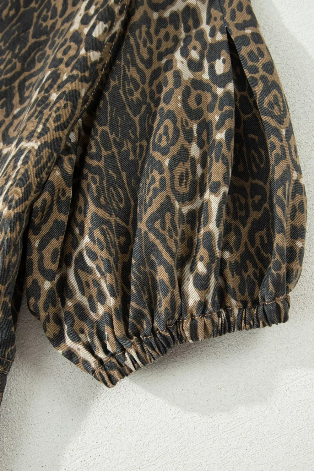 Denim dress with leopard print, puff sleeves, and elastic cuffs.