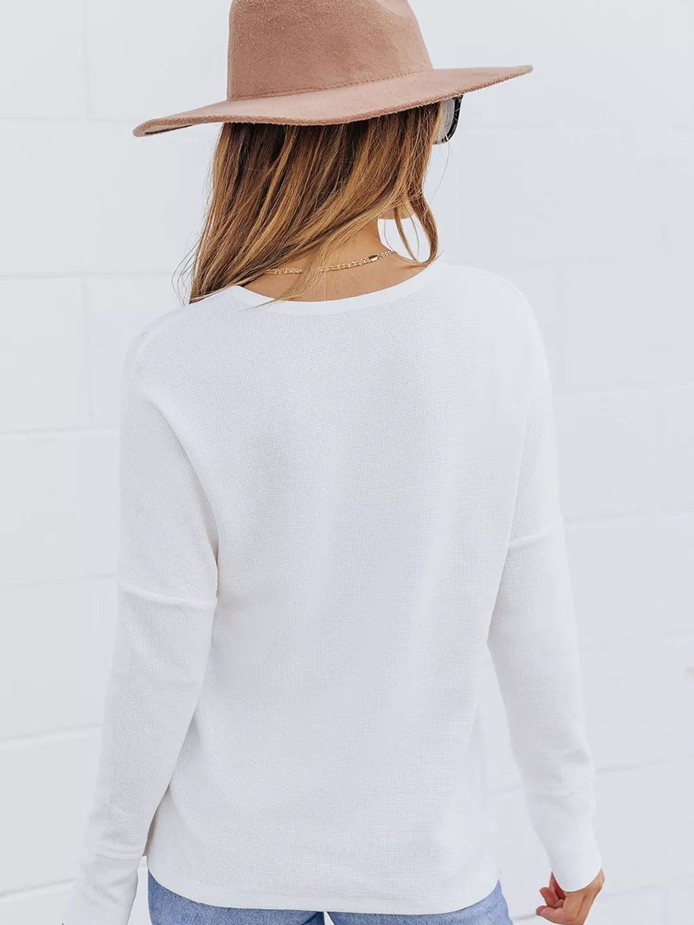 White textured cotton henley shirt with long sleeves and button detail visible from the back.
