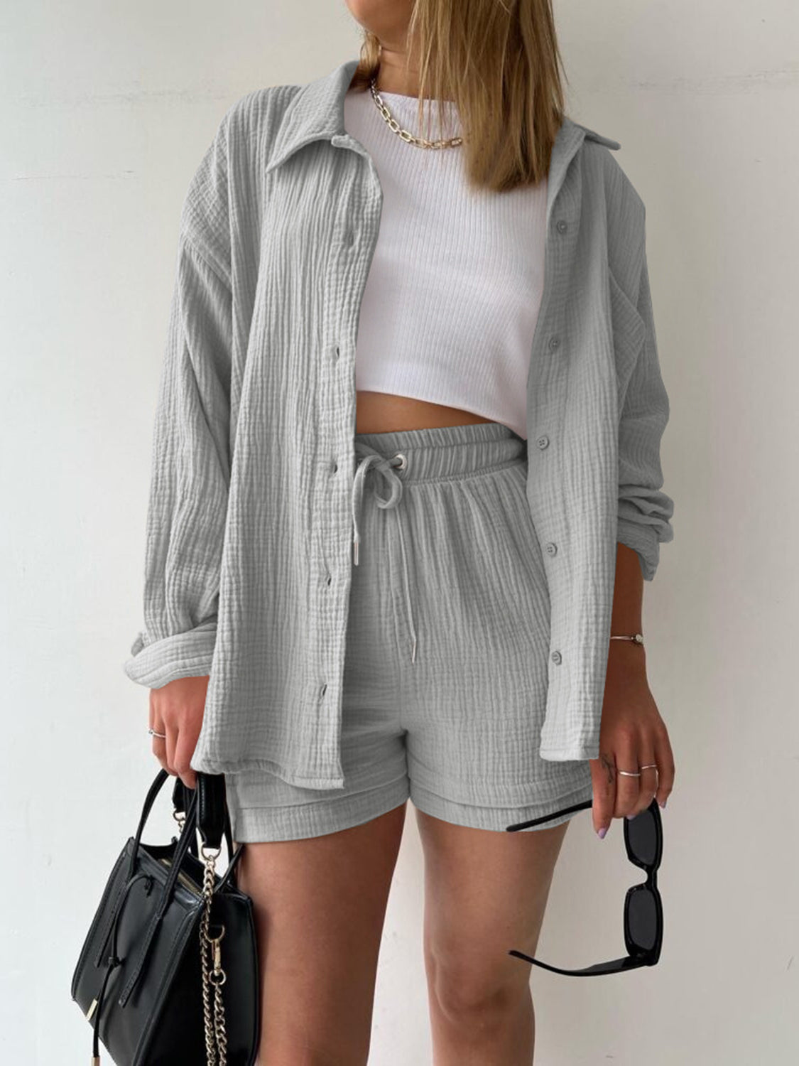 Light gray textured gauze button-down shirt and drawstring shorts set styled with a white crop top.