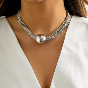 Choker necklace with layered silver chains and a large spherical pendant.