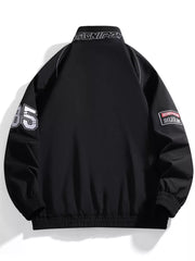 Black bomber jacket with racing-inspired details, "85" on sleeve, and embroidered patches.