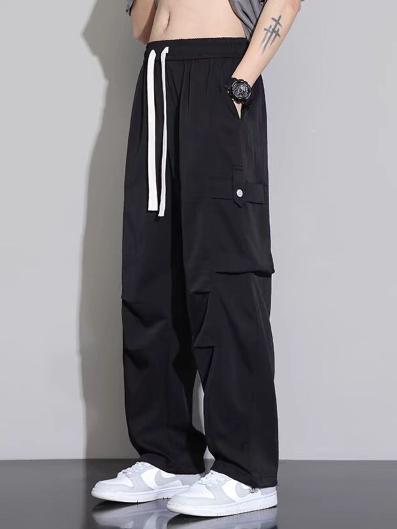 Men's black relaxed fit cargo sweatpants with white drawstring and side pockets.