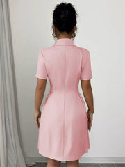 Blush pink double-breasted pleated blazer dress with short sleeves and a collared neckline.